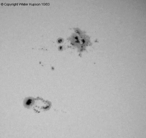 Photo by Walt Kupson
Sunspots AR 10486 & 10488
Taken by Walter Kupson 10/03
Celestron 4.5" Reflector, 12.5 mm Orthoscopic
Canon S30 3.2 megapixel digital camera, 1/500 sec, f/8
Homemade filter of Baader AstroSolar film

